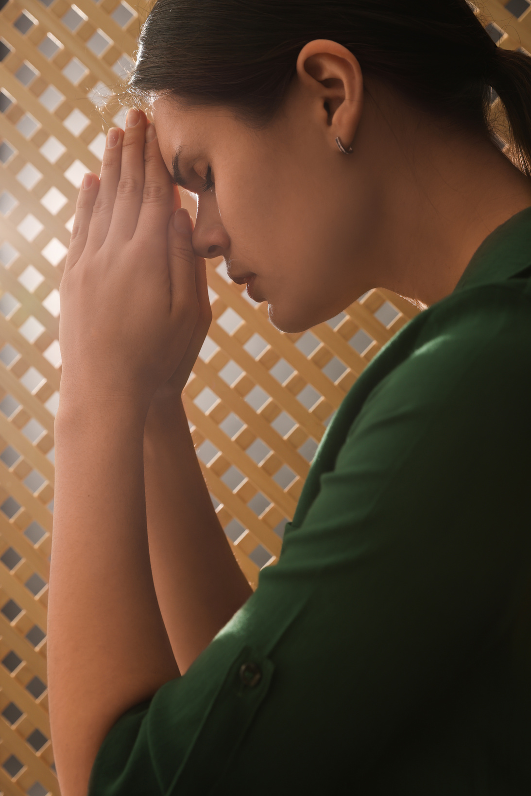 Woman Praying to God during Confession in Booth